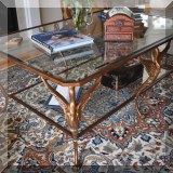 F03. Glass top coffee table with swan-shaped legs. 23”h x 58”w x 39”d 